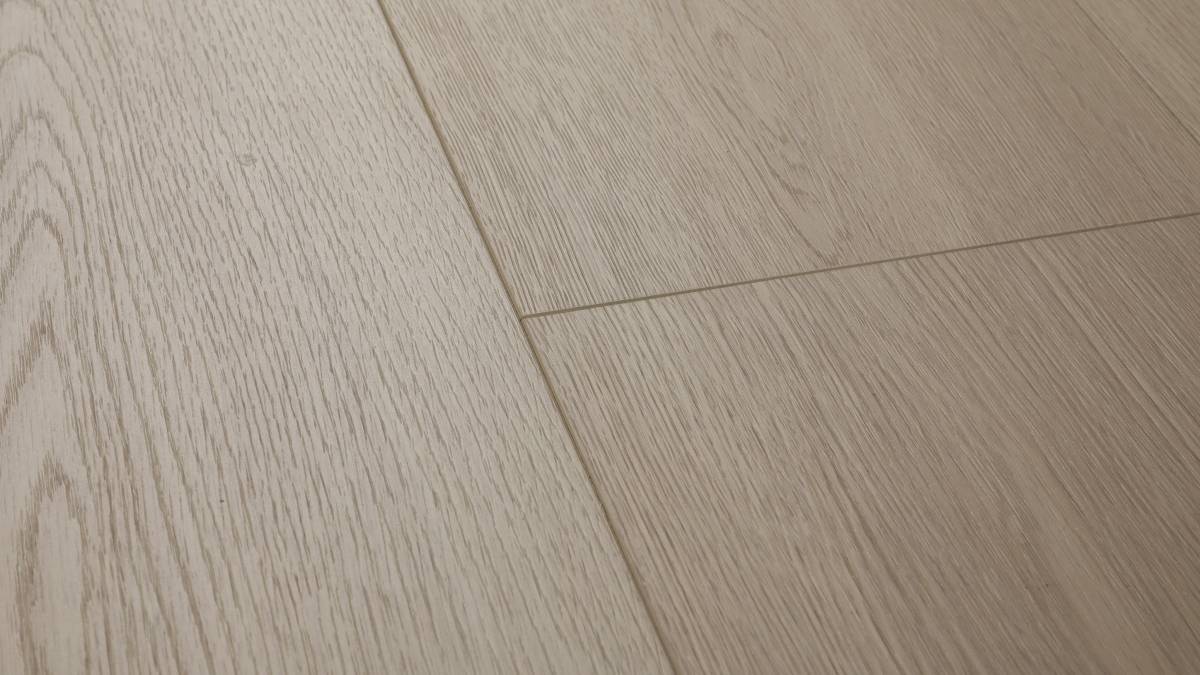 Mossy Stone AC5 laminate plank angle view showing 4-sided painted bevel and grey grain texture